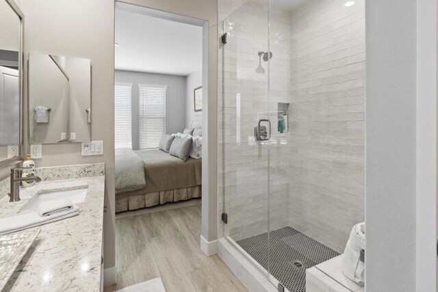 bathroom with vanity, a shower with door, and hardwood / wood-style floors