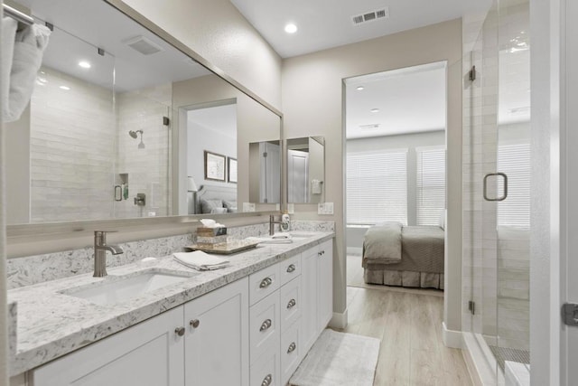 bathroom featuring an enclosed shower, vanity, and hardwood / wood-style floors