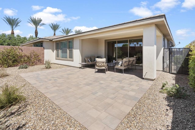 rear view of property with an outdoor living space and a patio