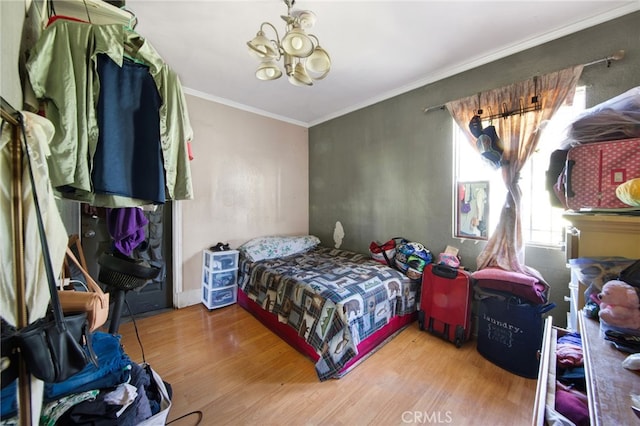 bedroom with a chandelier, ornamental molding, and hardwood / wood-style flooring