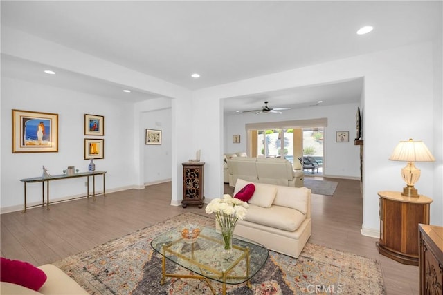 living room with ceiling fan and light wood-type flooring