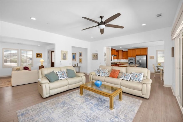 living room featuring ceiling fan and light hardwood / wood-style flooring