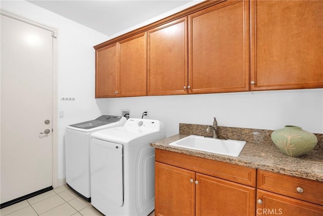 clothes washing area with sink, separate washer and dryer, cabinets, and light tile patterned flooring