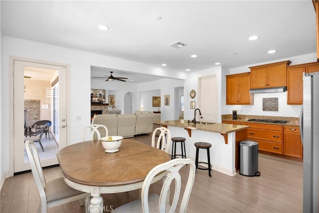 dining space with sink, ceiling fan, and light hardwood / wood-style floors