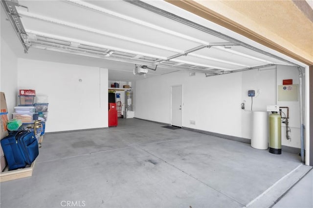 garage featuring a garage door opener and strapped water heater