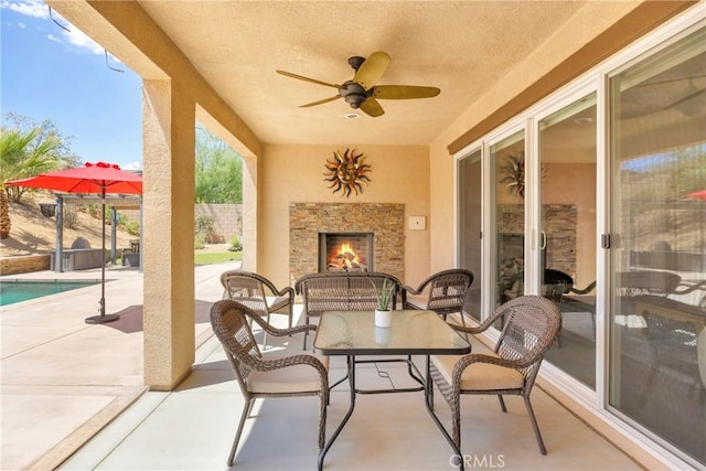 view of patio featuring a fenced in pool and an outdoor stone fireplace