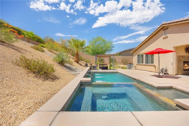 view of swimming pool with a patio area, an outdoor stone fireplace, and pool water feature