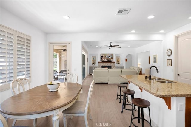 dining room featuring sink, light hardwood / wood-style floors, and ceiling fan