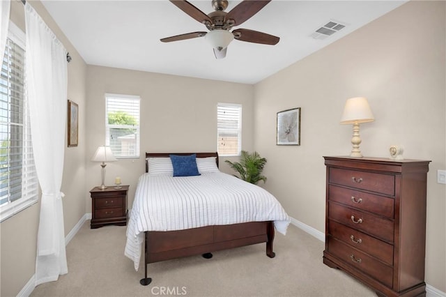 bedroom with ceiling fan, light carpet, and multiple windows