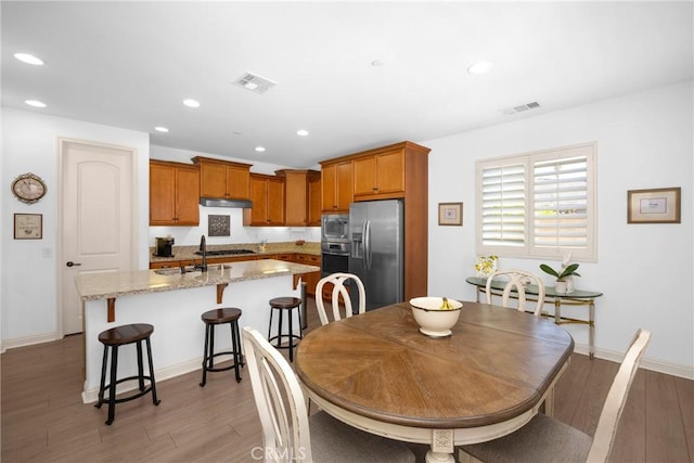 dining area with sink and wood-type flooring