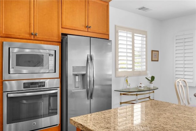 kitchen featuring stainless steel appliances and light stone counters