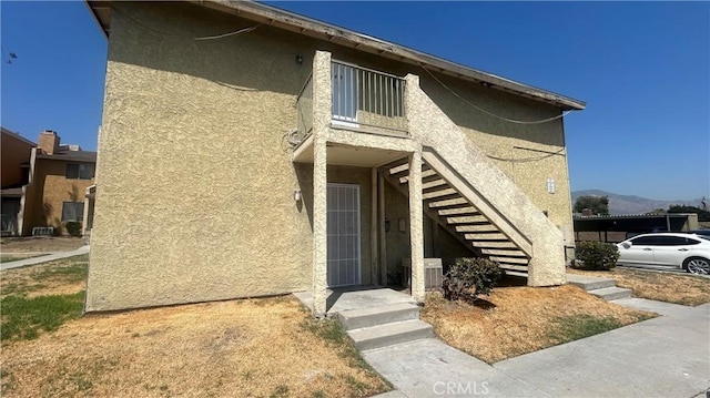 doorway to property with a mountain view and stucco siding