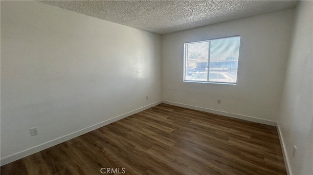 unfurnished room with a textured ceiling and dark hardwood / wood-style floors