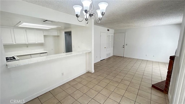 interior space with light tile patterned floors, baseboards, visible vents, an inviting chandelier, and a textured ceiling