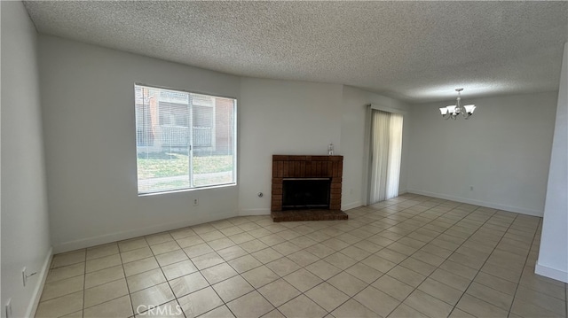 unfurnished living room with a textured ceiling, a fireplace, light tile patterned flooring, and a chandelier