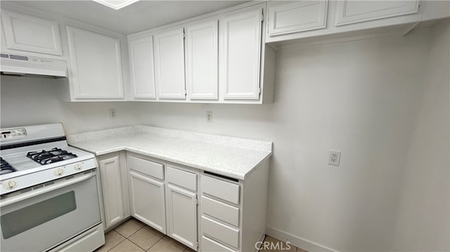 kitchen with premium range hood, light tile patterned floors, white gas range, and white cabinetry