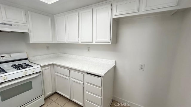 kitchen featuring light tile patterned floors, under cabinet range hood, white cabinets, light countertops, and white gas range oven