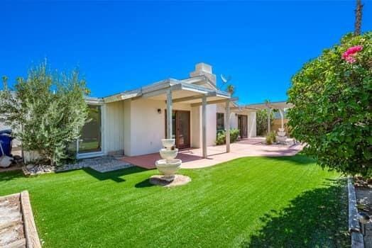 back of house with a patio and a yard