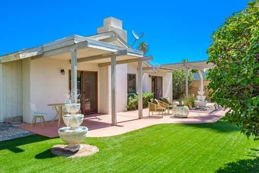 rear view of house with a lawn and a patio