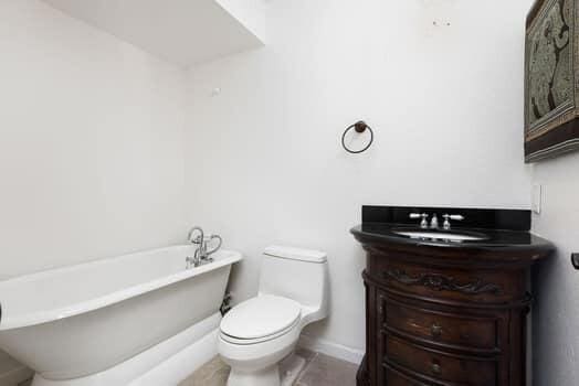 bathroom with vanity, tile patterned flooring, toilet, and a tub