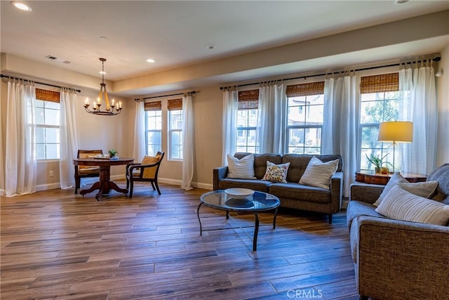 living room featuring an inviting chandelier and dark wood-type flooring