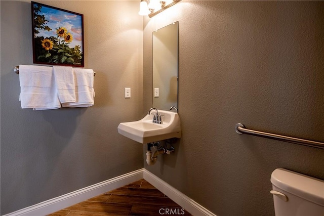 bathroom featuring sink, hardwood / wood-style floors, and toilet