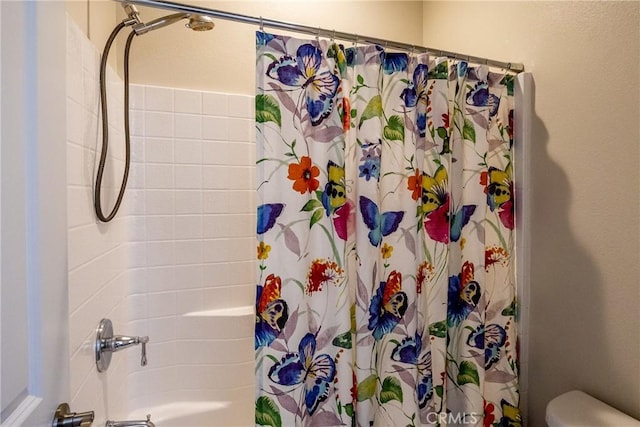 bathroom featuring shower / tub combo with curtain and toilet