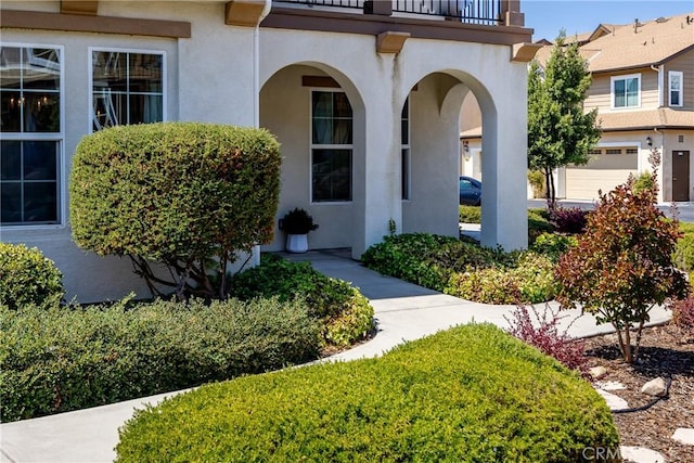 doorway to property with a balcony and a garage