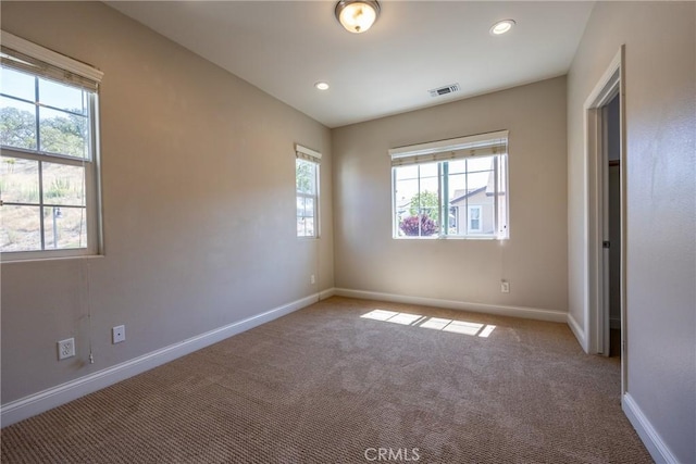 empty room with carpet floors and plenty of natural light