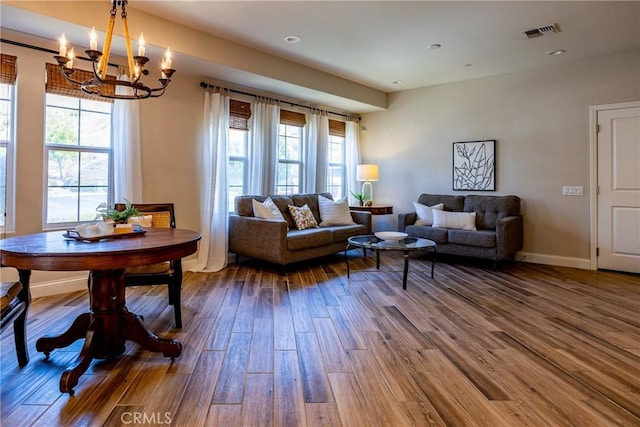 living room featuring wood-type flooring and a notable chandelier