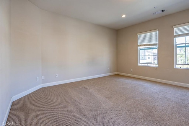 spare room featuring light colored carpet