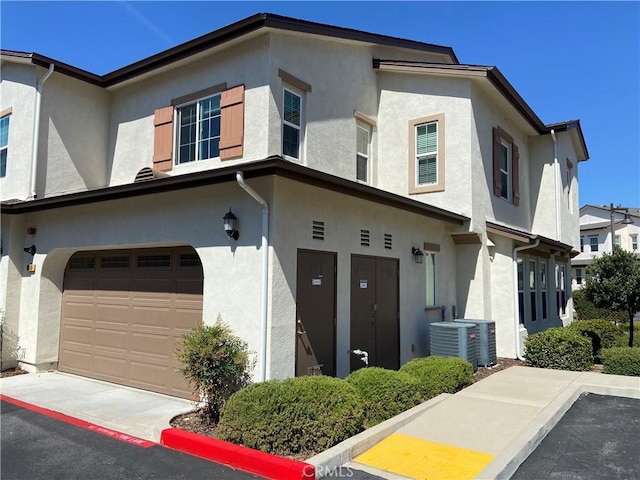 view of front of property with central AC and a garage