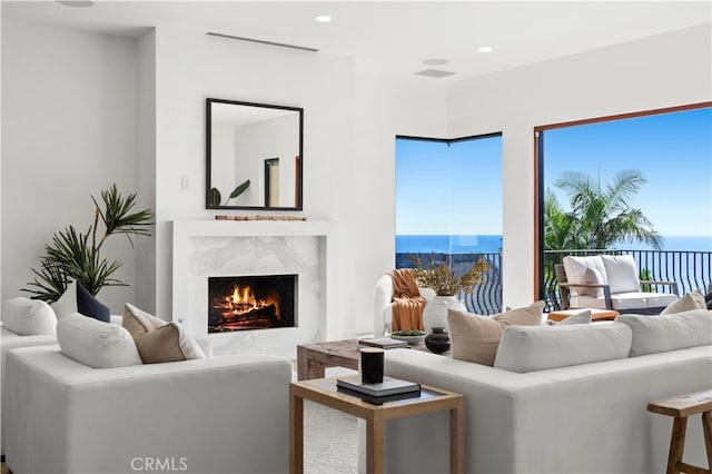 living room featuring a water view and a high end fireplace