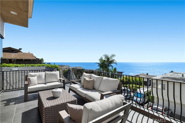 balcony with an outdoor living space and a water view