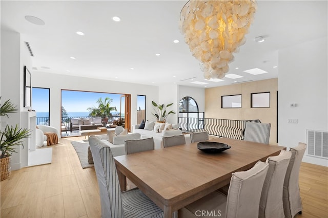 dining space featuring a chandelier, light hardwood / wood-style floors, and a healthy amount of sunlight