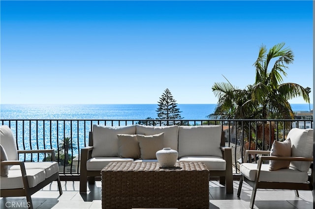 balcony featuring an outdoor living space and a water view