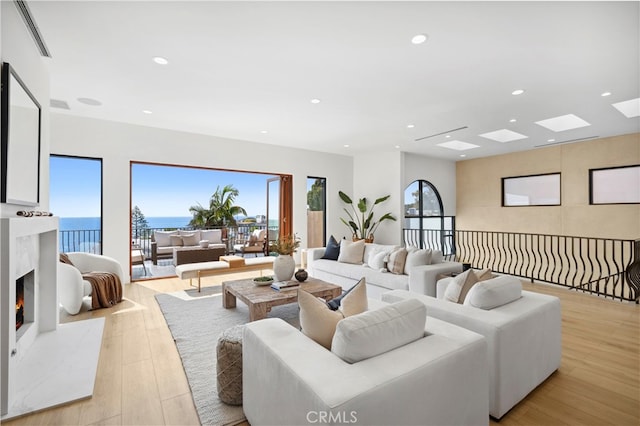 living room with light wood-type flooring and a high end fireplace