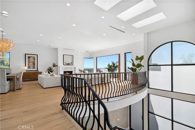 hall featuring light hardwood / wood-style flooring and a skylight