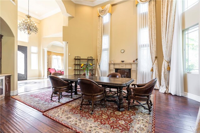805 W Road Ln, Habra Heights, CA 90631 - dining space featuring arched walkways, ornate columns, a towering ceiling, a fireplace, and ornamental molding