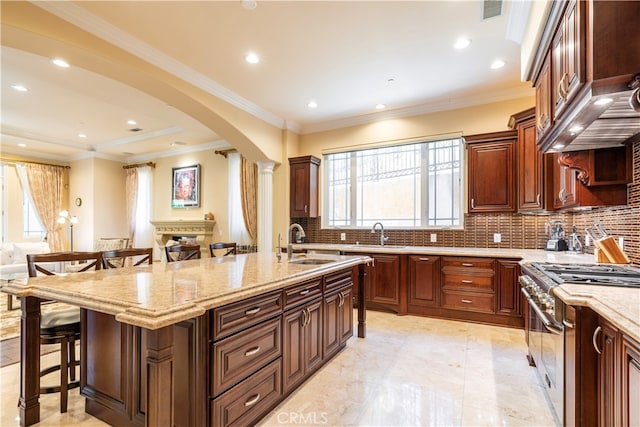 805 W Road Ln, Habra Heights, CA 90631 - kitchen featuring arched walkways, a sink, stainless steel gas range, a kitchen breakfast bar, and healthy amount of natural light