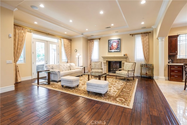 living room featuring hardwood / wood-style floors, ornate columns, and ornamental molding