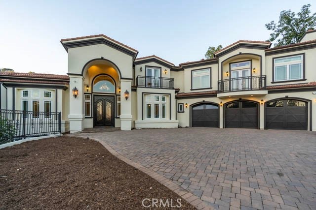 mediterranean / spanish home featuring a balcony, french doors, and a garage