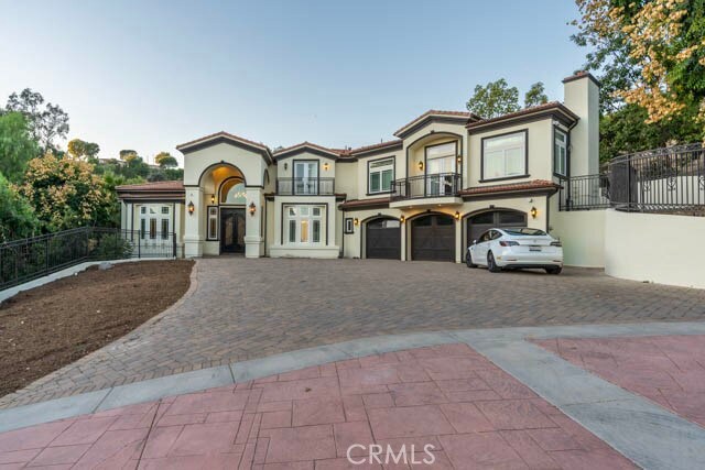805 W Road Ln, Habra Heights, CA 90631 - mediterranean / spanish-style home with a balcony, french doors, decorative driveway, an attached garage, and a chimney