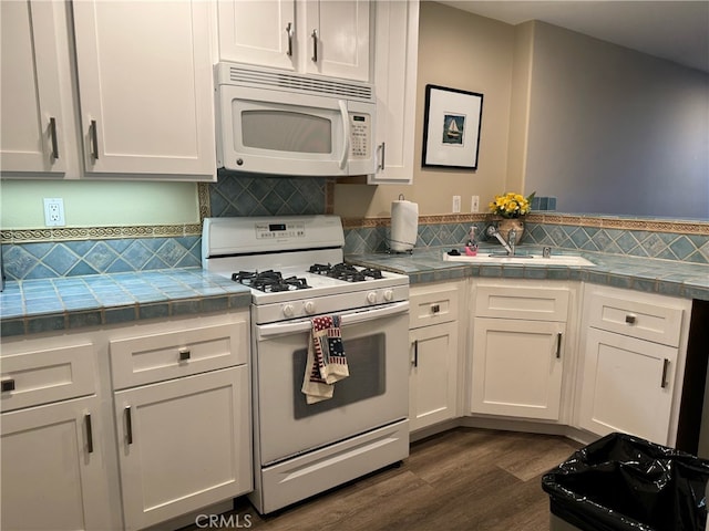 kitchen with white cabinets, white appliances, and dark hardwood / wood-style floors