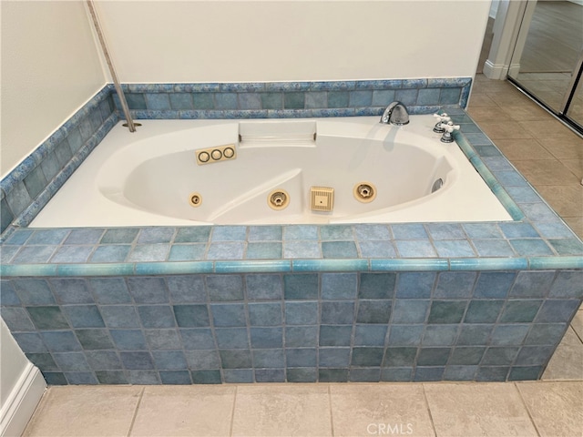 bathroom with tiled tub and tile patterned floors