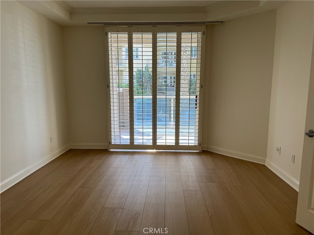 spare room featuring light hardwood / wood-style flooring and ornamental molding