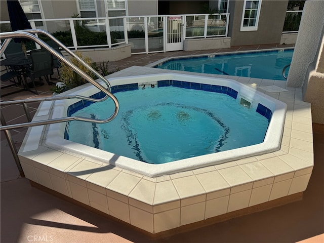 view of pool featuring a patio and a hot tub