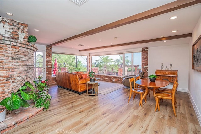 dining room with beamed ceiling and light wood-type flooring