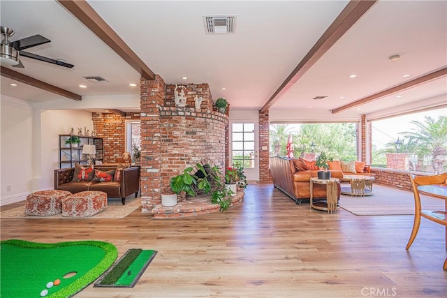 living room featuring beamed ceiling, light hardwood / wood-style floors, and ceiling fan