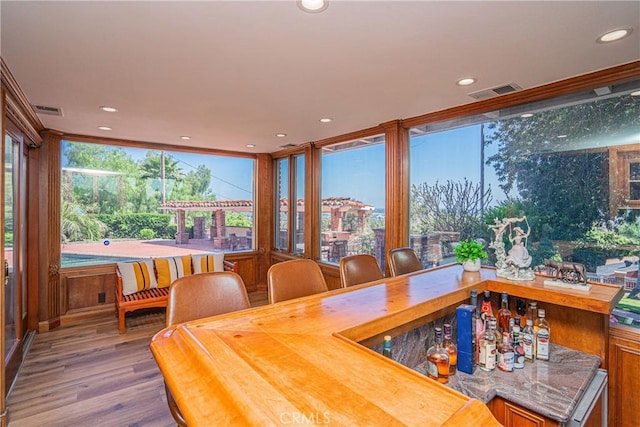 dining room featuring hardwood / wood-style floors and indoor bar